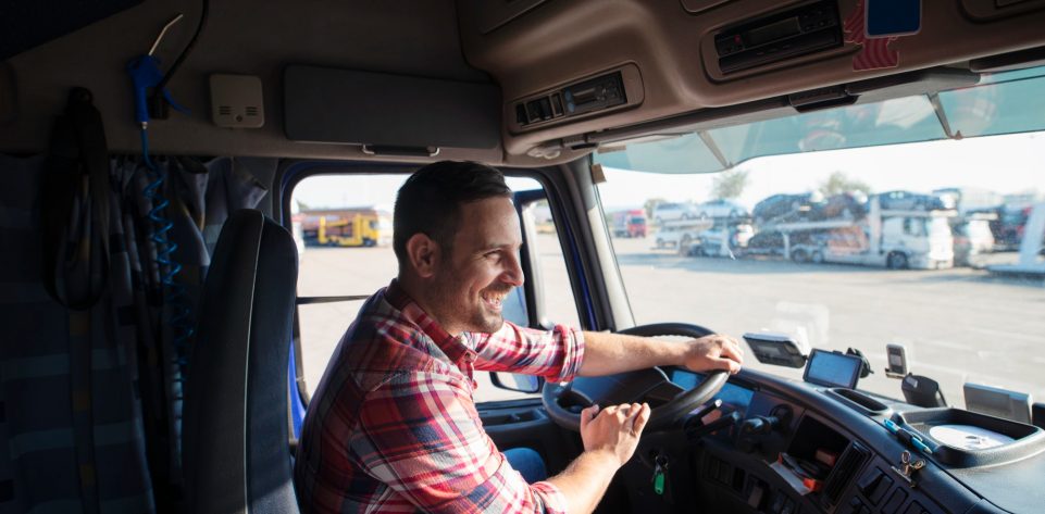 professional-truck-driver-with-smile-driving-truck-and-delivering-goods-on-time