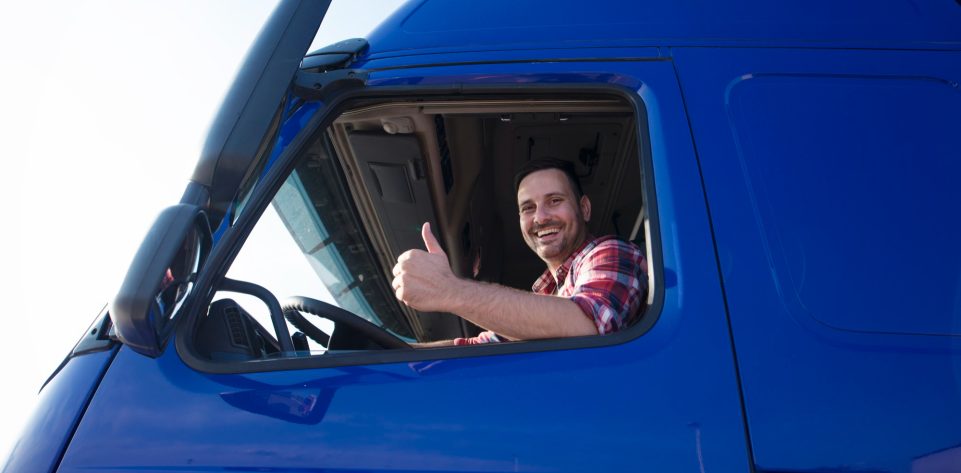 truck-driver-showing-thumbs-up-through-cabin-window